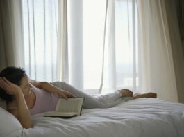 Læsning-i-sengen-med-gardinerne-for