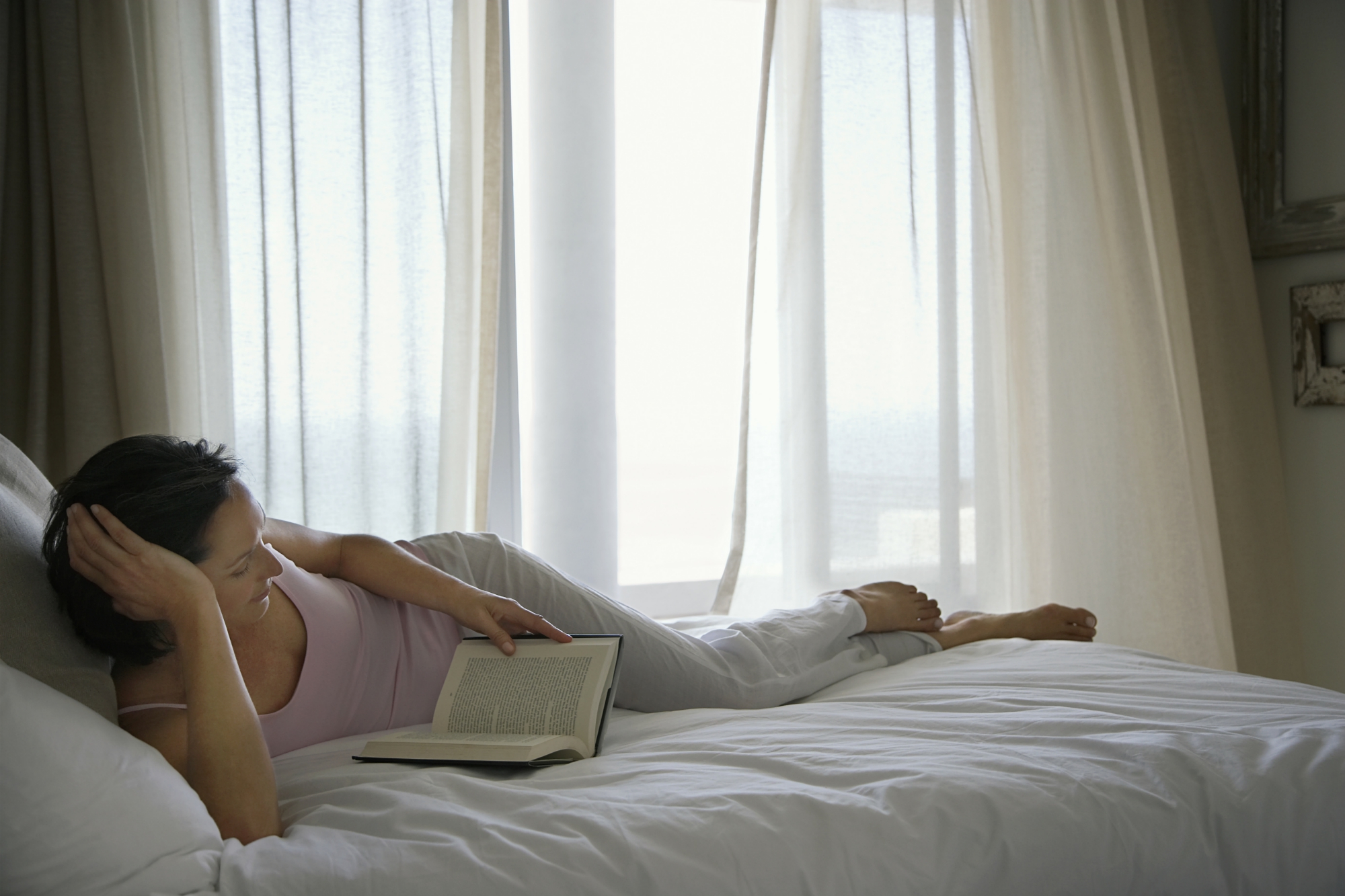 Læsning-i-sengen-med-gardinerne-for